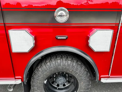 Closed side fill-port door detail on red body panel.